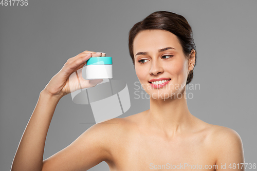 Image of happy young woman holding jar of cream