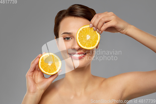 Image of beautiful woman making eye mask of orange slices