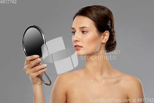 Image of beautiful young woman looking to mirror