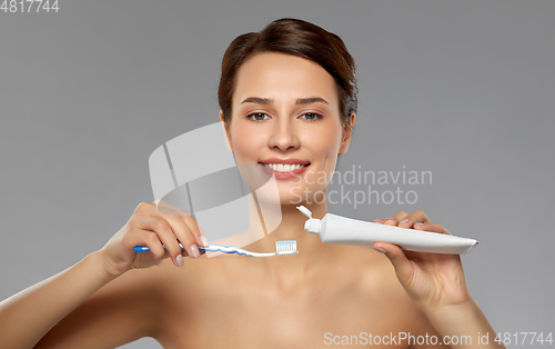 Image of smiling woman with toothbrush cleaning teeth