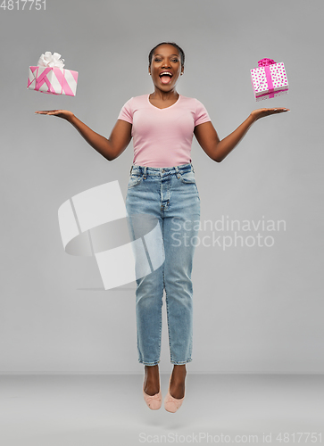 Image of happy african american woman with gift boxes