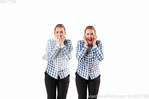 Image of Young handsome woman arguing with herself on white studio background.