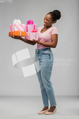 Image of happy african american woman with gift boxes