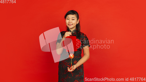 Image of Happy Chinese new year. Asian young girls\'s portrait isolated on red background