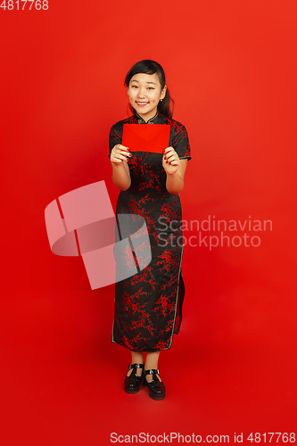 Image of Happy Chinese new year. Asian young girls\'s portrait isolated on red background