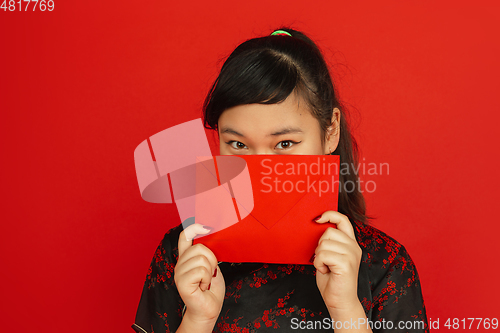 Image of Happy Chinese new year. Asian young girls\'s portrait isolated on red background