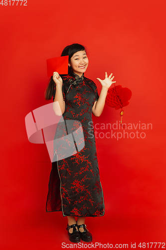 Image of Happy Chinese new year. Asian young girls\'s portrait isolated on red background