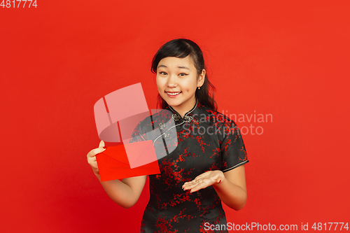 Image of Happy Chinese new year. Asian young girls\'s portrait isolated on red background