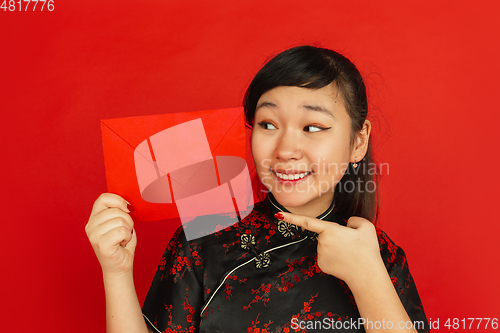 Image of Happy Chinese new year. Asian young girls\'s portrait isolated on red background