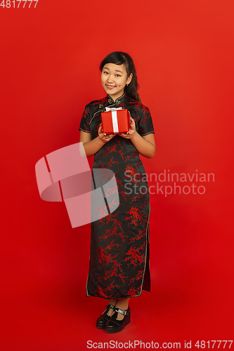 Image of Happy Chinese new year. Asian young girls\'s portrait isolated on red background