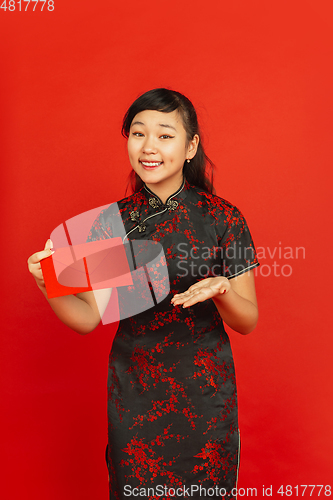 Image of Happy Chinese new year. Asian young girls\'s portrait isolated on red background