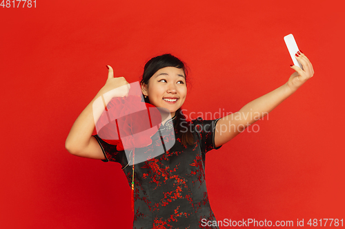 Image of Happy Chinese new year. Asian young girls\'s portrait isolated on red background