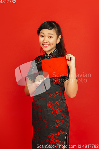 Image of Happy Chinese new year. Asian young girls\'s portrait isolated on red background