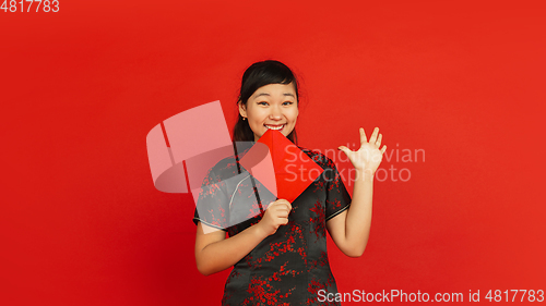 Image of Happy Chinese new year. Asian young girls\'s portrait isolated on red background