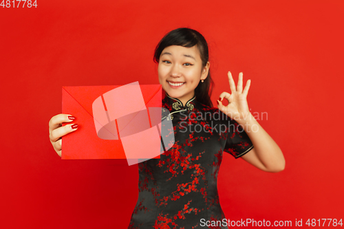 Image of Happy Chinese new year. Asian young girls\'s portrait isolated on red background
