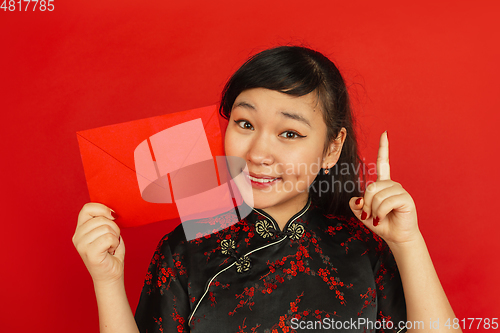 Image of Happy Chinese new year. Asian young girls\'s portrait isolated on red background