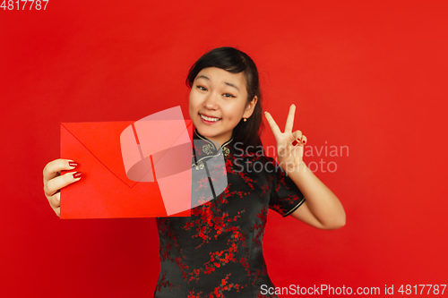 Image of Happy Chinese new year. Asian young girls\'s portrait isolated on red background