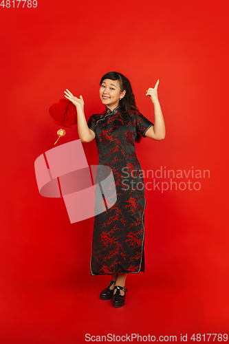 Image of Happy Chinese new year. Asian young girls\'s portrait isolated on red background