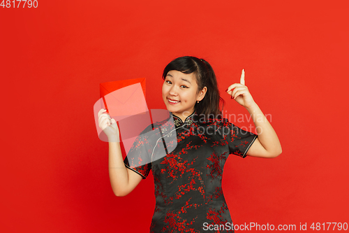 Image of Happy Chinese new year. Asian young girls\'s portrait isolated on red background