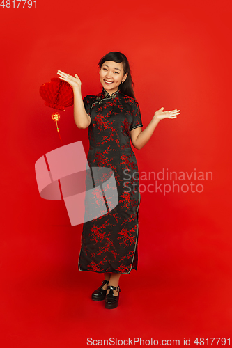 Image of Happy Chinese new year. Asian young girls\'s portrait isolated on red background