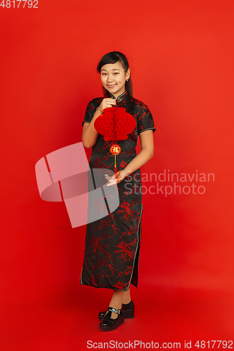 Image of Happy Chinese new year. Asian young girls\'s portrait isolated on red background