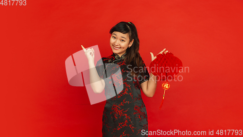 Image of Happy Chinese new year. Asian young girls\'s portrait isolated on red background