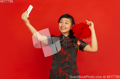 Image of Happy Chinese new year. Asian young girls\'s portrait isolated on red background