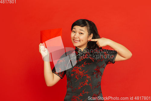 Image of Happy Chinese new year. Asian young girls\'s portrait isolated on red background