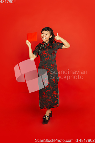 Image of Happy Chinese new year. Asian young girls\'s portrait isolated on red background