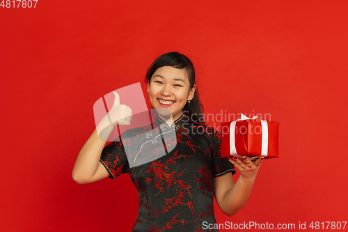 Image of Happy Chinese new year. Asian young girls\'s portrait isolated on red background