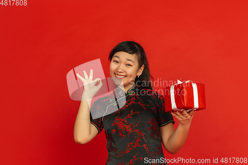 Image of Happy Chinese new year. Asian young girls\'s portrait isolated on red background