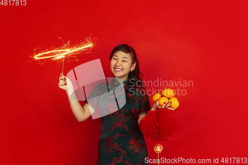 Image of Happy Chinese New Year. Asian young girls\'s portrait isolated on red background