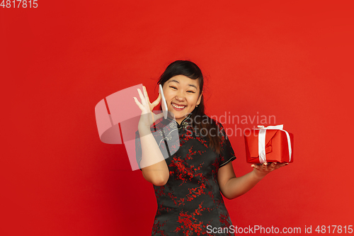 Image of Happy Chinese New Year. Asian young girls\'s portrait isolated on red background