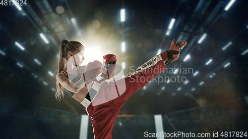 Image of Young female kickboxing fighter training in the gym