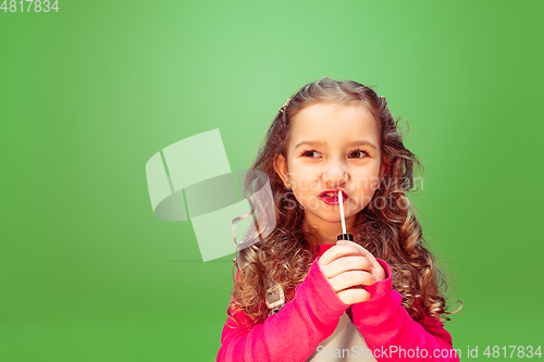 Image of Little girl dreaming about future profession of makeup artist