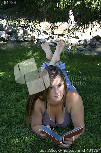 Image of Beautiful Girl in the Park Reading a Book