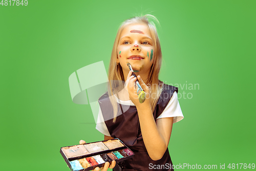 Image of Little girl dreaming about future profession of makeup artist