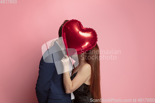 Image of Valentine\'s day celebration, happy caucasian couple isolated on coral background