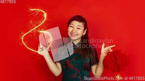 Image of Happy Chinese New Year. Asian young girls\'s portrait isolated on red background