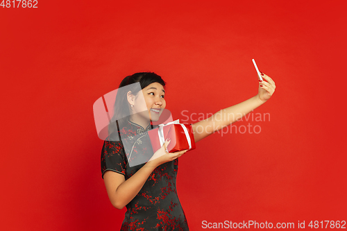 Image of Happy Chinese New Year. Asian young girls\'s portrait isolated on red background