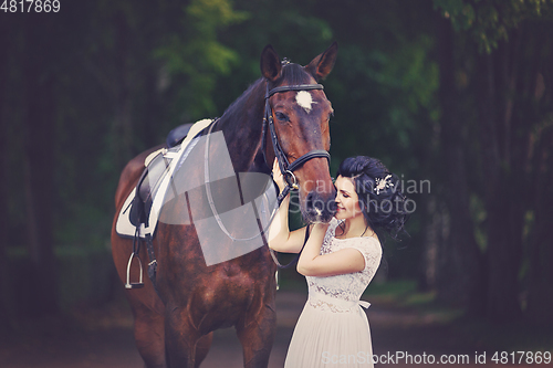 Image of beautiful girl in dress with horse