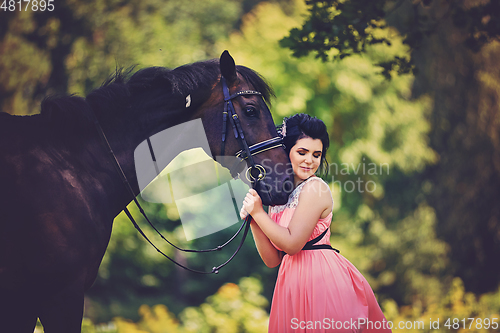 Image of beautiful girl in dress with horse