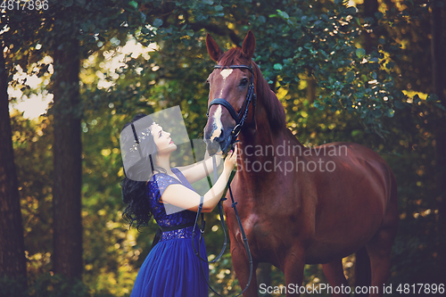 Image of beautiful girl in dress with horse