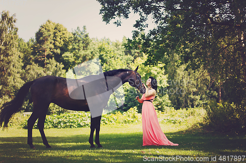 Image of beautiful girl in dress with horse