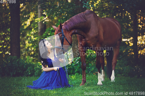 Image of beautiful girl in dress with horse