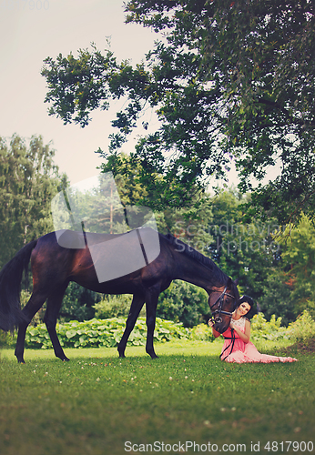 Image of beautiful girl in dress with horse