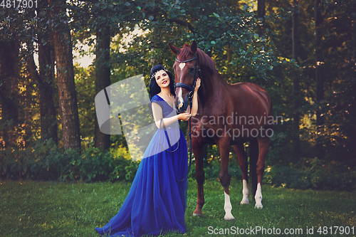 Image of beautiful girl in dress with horse