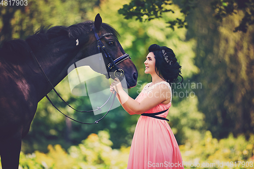 Image of beautiful girl in dress with horse