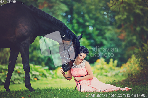 Image of beautiful girl in dress with horse