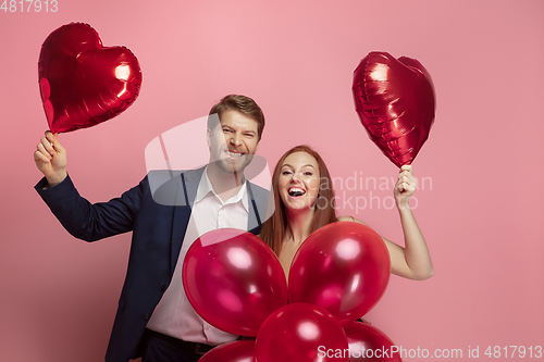 Image of Valentine\'s day celebration, happy caucasian couple isolated on coral background